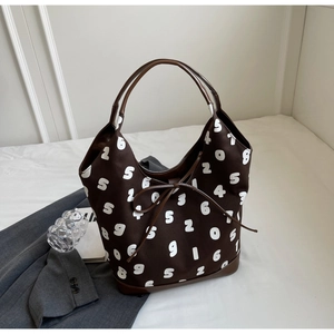 Detailed view of brown canvas hobo bag with white number patterns and bow detail