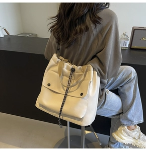 Détail du sac cabas en toile crème avec fermeture à cordon et bandoulière noire