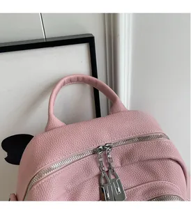 Detail view of pink lychee texture leather backpack with double zipper and top handle