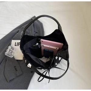 Spacious interior of black hobo bag showing capacity for tablets and smart phones