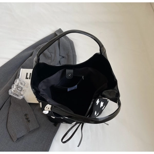Top view of large black bucket bag featuring white graffiti print and magnetic closure