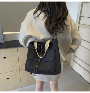 Détail du sac fourre-tout en nylon noir avec sangles kaki et cordon de serrage porté