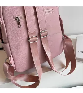 Detail of pink faux leather backpack featuring litchi texture and adjustable straps