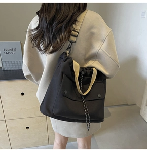 Détail du sac fourre-tout en toile avec cordon de serrage et bandoulières beiges contrastées