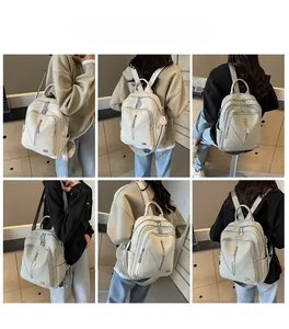 Detail view of white faux leather backpack with V-shape zipper and silver hardware