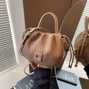 Détail du sac seau plissé beige avec boucle carrée et texture douce de qualité