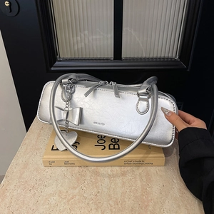 Détails du sac baguette argenté avec texte NO FILTER et pendentif en forme de cœur