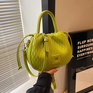 Détail du sac seau vert néon avec texture plissée ondulée et cordon de serrage
