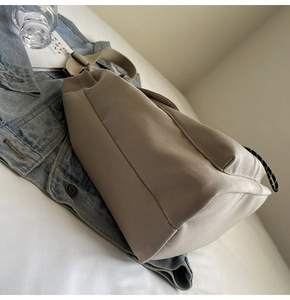 Détail du sac fourre-tout en toile kaki avec bandoulière large et tirette tissée