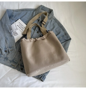 Détail du sac cabas en toile kaki avec bandoulières réglables et design plissé décontracté