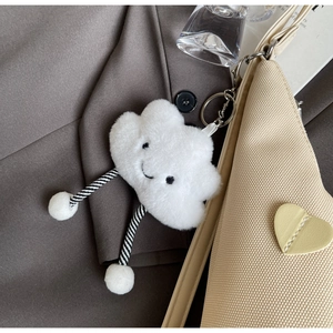 Dettaglio del ciondolo a nuvola in peluche bianco con gambe a righe sulla borsa