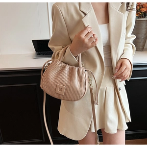 Vue détaillée du sac seau plissé beige avec texture nuage douce et accents en cuir