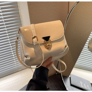 Détail du sac en cuir plissé blanc cassé avec une boucle triangulaire métallique chic