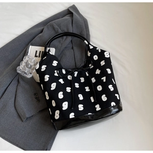 Detailed view of canvas tote bag with numeric pattern and leather base on grey blazer