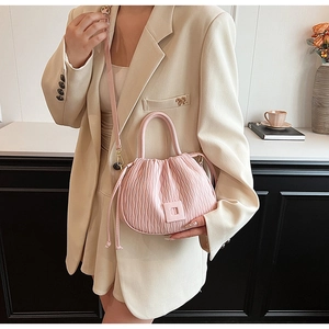 Détails du sac seau plissé rose montrant la texture douce et la bandoulière amovible