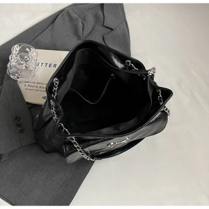 Top view of black tote bag interior showing zipper pockets and silver chain strap details