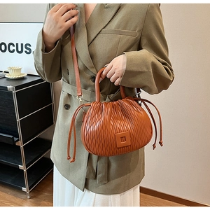 Détail du sac seau plissé caramel avec texture verticale et bandoulière réglable