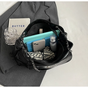 Top view showing large capacity interior of black tote bag with silver chain strap