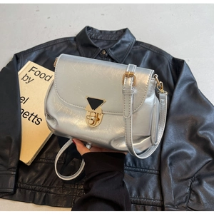 Détail du sac plissé argenté avec fermoir doré et finition métallique brillante