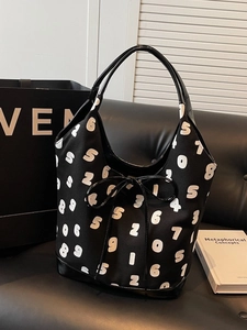 Minimalist black canvas tote bag with white number print and leather bow accent