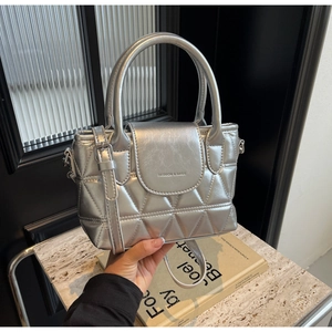 Detail of silver quilted bucket bag featuring fashion lettering and metallic PU leather texture
