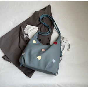 Dettaglio borsa tote grigio-blu con toppe a cuore colorate e ciondolo nuvola in peluche