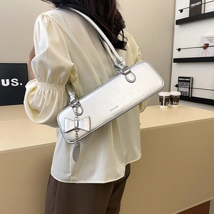 Détail du sac argenté métallisé avec texture craquelée et breloque chaîne à nœud