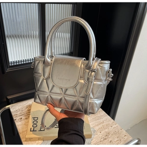 Detail of silver quilted bucket bag with geometric triangles and branded fashion lettering