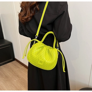 Détail du sac seau plissé vert fluo avec texture ondulée et bandoulière réglable