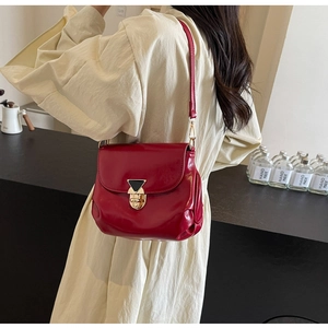 Détail du sac bandoulière plissé rouge brillant avec ferrures dorées et plis latéraux