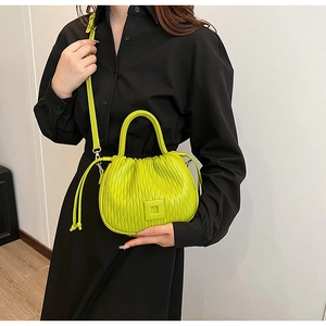 Détail de la texture plissée ondulée d'un sac seau vert citron pour femme élégante