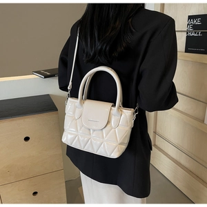 Detail of cream quilted leather bucket bag featuring a fashion letter print flap