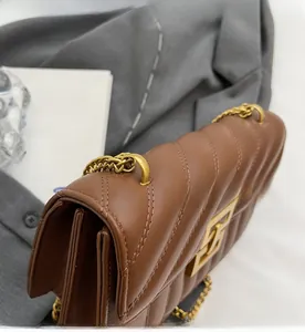 Détail du sac en cuir matelassé marron avec boucle dorée et côtés en accordéon