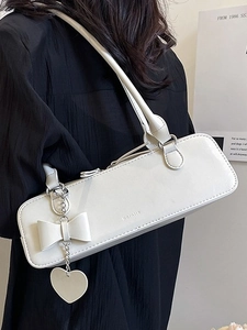 Sac baguette beige minimaliste avec chaîne argentée et pendentif nœud à l'épaule
