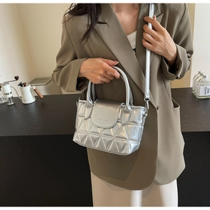 Detail of silver quilted bucket bag with triangular pattern and metallic finish