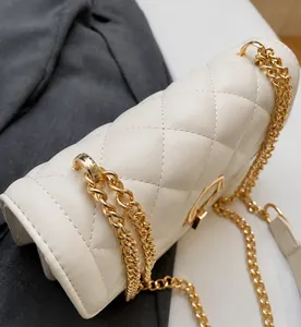 Detail of premium beige quilted crossbody bag with golden chain and metallic buckle