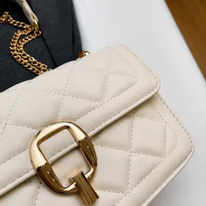 Close-up of cream quilted crossbody bag featuring soft leather texture and golden clasp