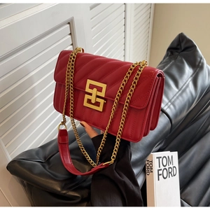 Détail d'un sac à main en cuir matelassé rouge avec fermoir doré et bandoulière chaîne