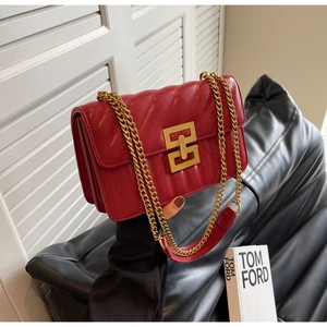 Détail du sac à main en cuir matelassé rouge avec fermoir doré et bandoulière