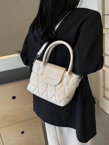 Quilted cream crossbody bucket bag in glossy faux leather with elegant top handle