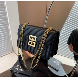 Détail du sac en cuir matelassé noir avec boucle dorée carrée et bandoulière en chaîne