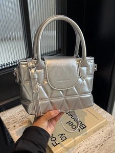 Silver metallic quilted bucket bag with triangular stitching and top handle strap