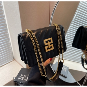 Détail du sac en cuir matelassé noir avec fermoir carré doré et bandoulière chaîne