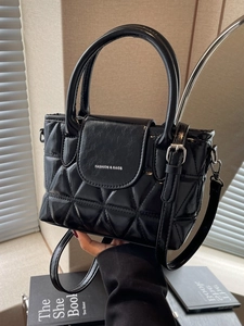 Chic black quilted bucket bag with adjustable crossbody strap and silver lettering