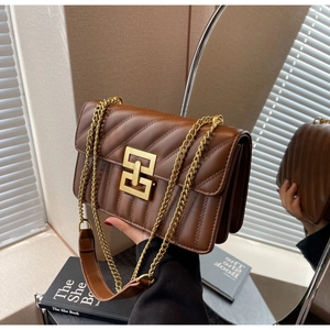 Détail d'un sac à chaîne en cuir matelassé marron avec fermoir doré et structure accordéon