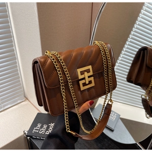 Détail du sac en cuir matelassé marron avec boucle dorée et structure latérale en accordéon