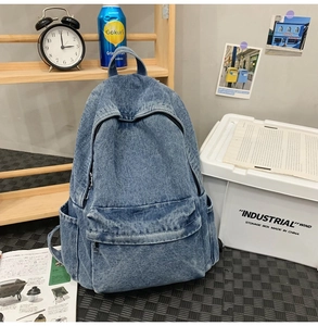 Detail of a vintage dark blue washed denim backpack in a stylish home decor setting