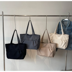 Detail of multi-color minimalist canvas tote bags in black, grey, khaki and beige