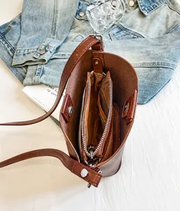 Vista dall'alto dell'interno della borsa marrone con tasca a zip sicura e rivetti metallici