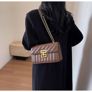 Détail du sac à bandoulière en cuir marron matelassé avec boucle carrée dorée chic